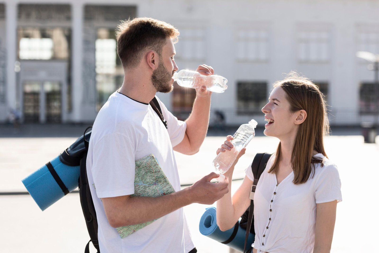 side-view-tourist-couple-staying-hydrated-outdoors